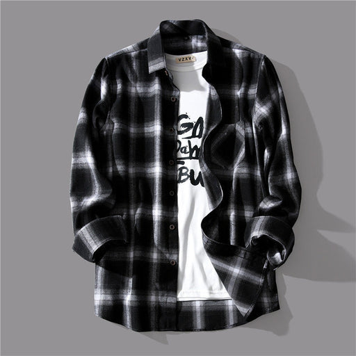 Loose casual long sleeve shirt in black and white plaid design layered over a white graphic tee.