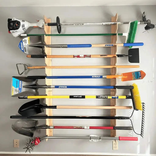 Wall-mounted garden tool rack organizing shovels, rakes, and brooms in a garage with wooden precision-CNC-cut construction